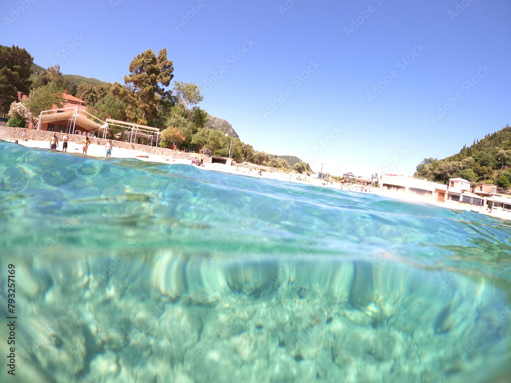 Blue sky with sand underwater sea, split view over and under water surface, corfu,Greece Blue sky with sand underwater sea, split view over and under water surface, corfu,Greece