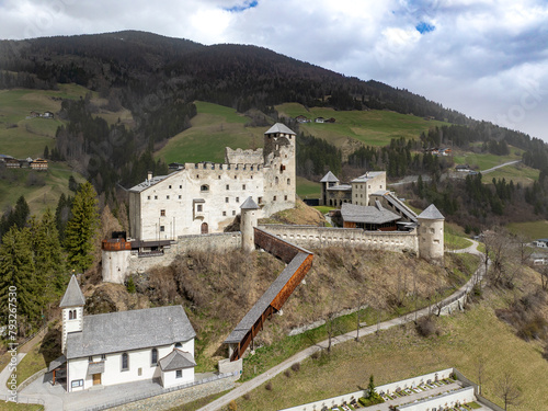 Medieval Heinfels Castle in Panzendorf near Sillian in Puster Valley in Austria. Build in 13th century. Fortified fortress with a tower, surrounding wall,  long wooden staircase and a small church photo
