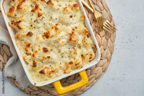 Photos A cheesy macaroni and cheese cauliflower casserole in a yellow handled dish
