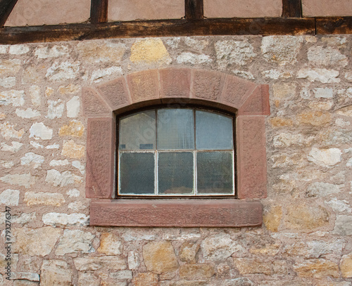 Vintage European window, glass window framed by stone wall, exterior	
