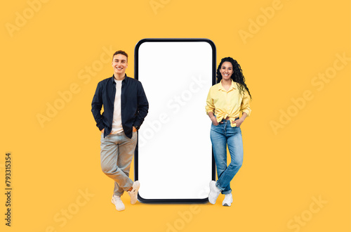 Youthful duo next to blank smartphone screen mockup