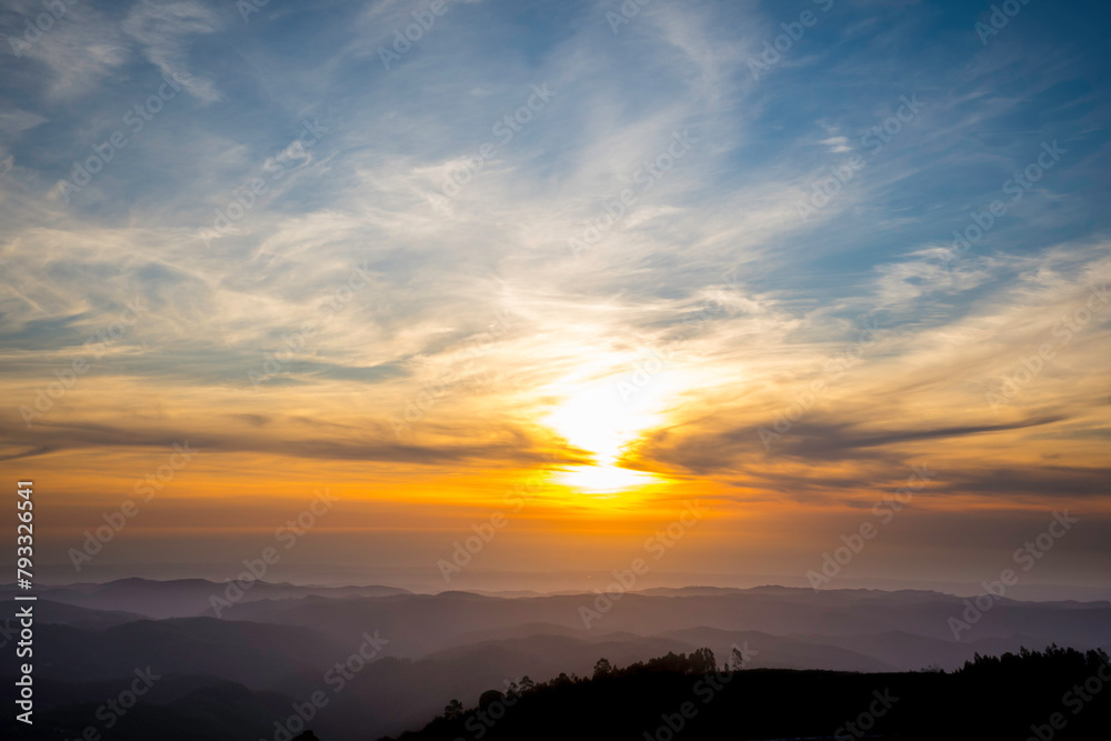 Dramatic sunset sky over rolling mountains