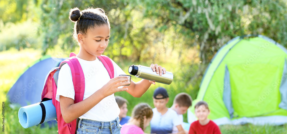 © Pixel-Shot - African-American girl with thermos resting at summer camp