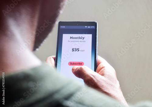 Man managing monthly subscription plan for streaming service or educational program or delivery benefits on his smartphone. selective focus.