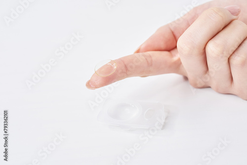 コンタクトレンズを持つ女性の指
