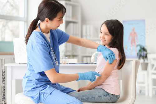 Little Asian girl receiving vaccine in clinic photo