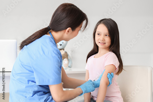 Little Asian girl receiving...
