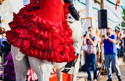 traditional spanish woman red dress riding a horse