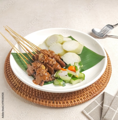 Sate Madura. Chicken Satay with peanuts sauce on white plate and white background. Typical food from Java, Indonesia.
