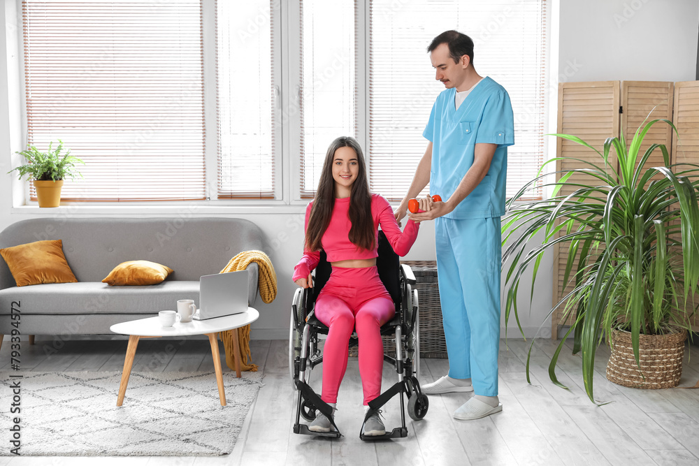 Sporty young woman in wheelchair with dumbbell and physiotherapist training at home Sporty young woman in wheelchair with dumbbell and physiotherapist training at home