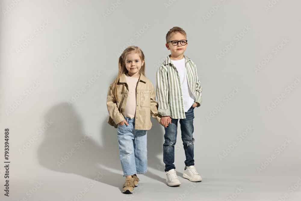 Fashion concept. Stylish children posing on light grey background Fashion concept. Stylish children posing on light grey background