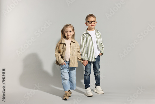 Fashion concept. Stylish children posing on light grey background