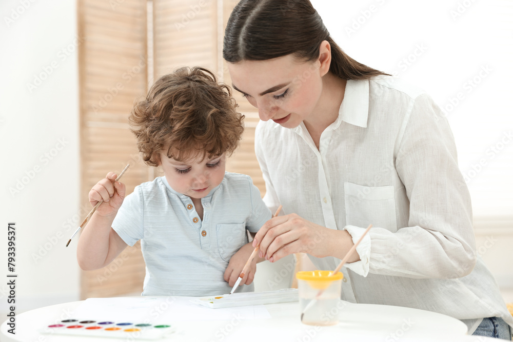 Mother and her little son painting with watercolor at home Mother and her little son painting with watercolor at home