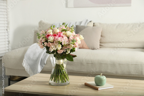 Beautiful bouquet of fresh flowers in vase on wooden table indoors