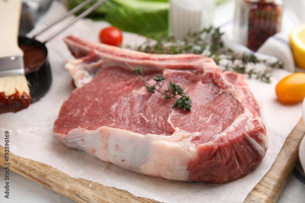 Raw meat, thyme and marinade on table, closeup Raw meat, thyme and marinade on table, closeup