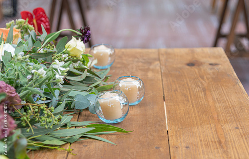 3 velas sobre la mesa junto al centro de mesa flores de boda