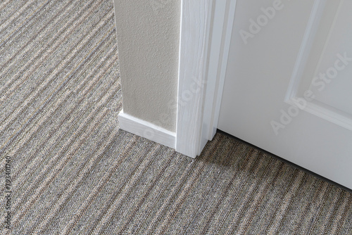 Outside corner baseboard moulding installed in a room with low pile carpet