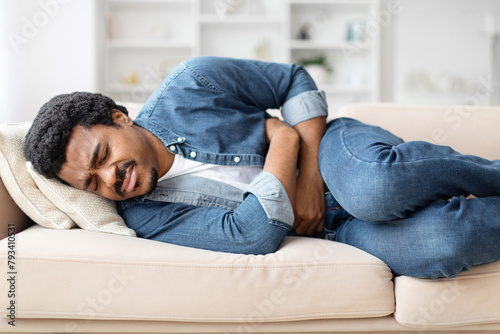 Casual Young Black Man Suffering From Stomachache at Home