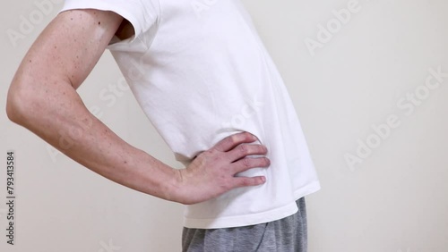 腰に手を当てて背中を反らせる男性