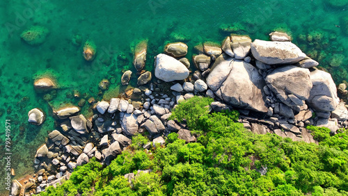 Obraz na plátně Above the tranquil expanse of blue waters, a drone offers a breathtaking view of the tropical island's rocky cliffs and emerald-green jungles