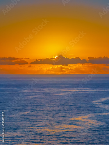 Sunrise over the sea and rocks with clear skies © Merrillie