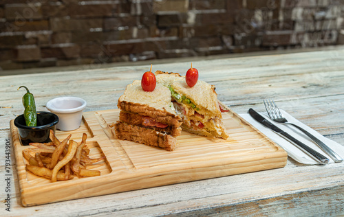 sandwich con papas sobre tablilla de madera 
