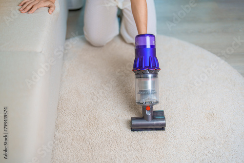 Woman cleaning Carpet with cordless Vacuum cleaner. Housewife using wireless Vacuum for big cleaning home. Housework, Housecleaning, Housekeeping, Removes dust, Domestic hygiene and daily routine