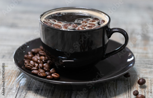 taza negra de cafe con granos al lado 