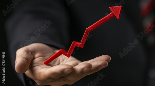 Close view of a businessman's hand holding a falling arrow, depicting investment loss and economic downturn,