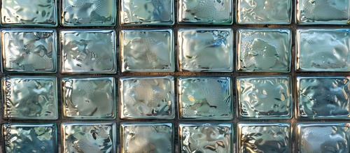 Close-up view of a textured wall made of glass blocks, featuring an abundance of water droplets creating a glistening effect