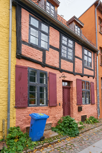 Wohnhaus in der historischen Altstadt von Stralsund mit einer blauen Tonne für das Recycling von Papier