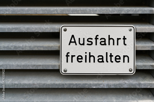 Schild am Tor eines Parkhauses mit der deutschen Aufschrift Ausfahrt freihalten