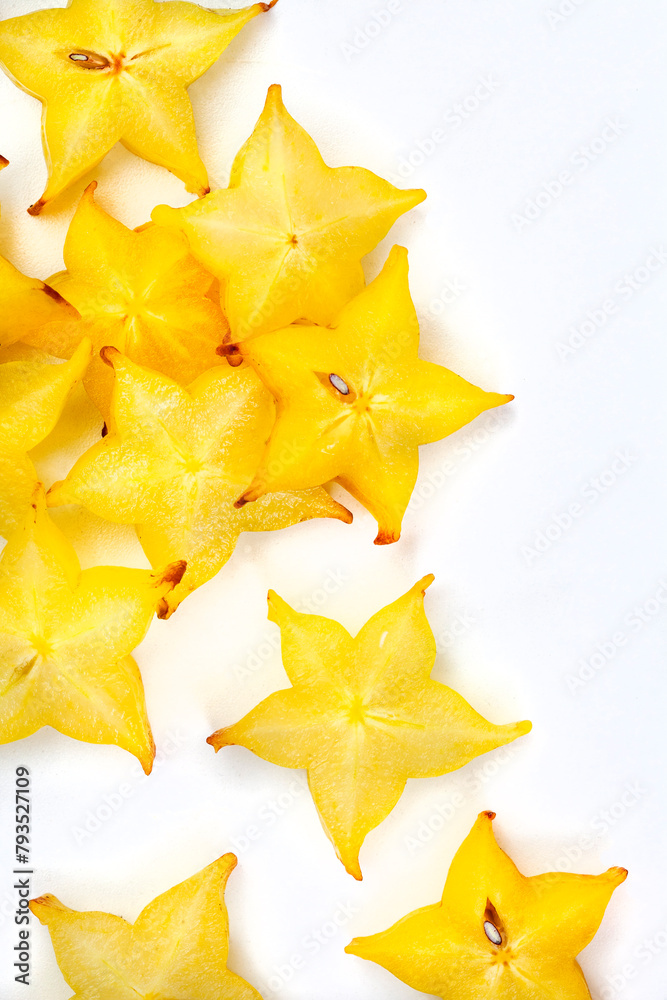 star fruit slices scattered on white, with copy space star fruit slices scattered on white, with copy space