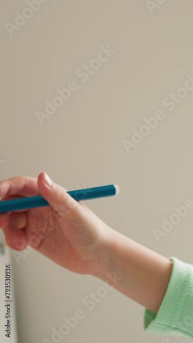 Girl takes off cap from felt-tip pen and stretches out hand photo