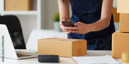 Close up woman entrepreneur working at home office and taking a parcel photo before delivery