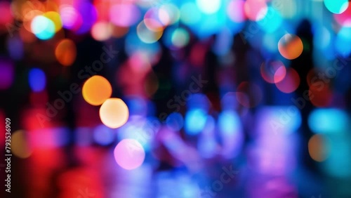 Blurred bursts of colorful spotlights shining down on a dimly lit dance floor the silhouetted figures of people moving to the rhythm ly visible in the background. . photo