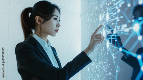 A female engineer in formal attire, pointing at a LED display, instructive and dynamic, against a stark white background, styled as a technology demonstration. photo