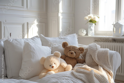 Scandinavian hygge interior design of modern white living room, white sofa with teddy bear home. Clear light through window.