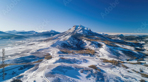Aerial view of majestic beauty of a snow-capped mountain range under a clear blue sky