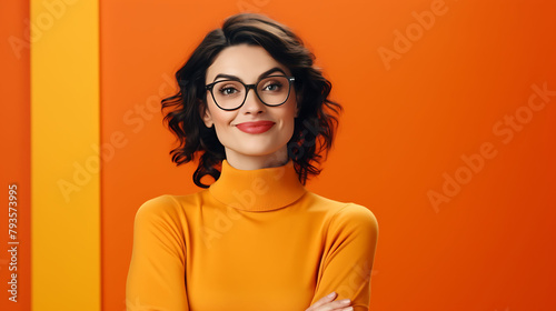 Confident young woman in glasses, arms crossed, smiling warmly, on a solid orange background, projecting self-assurance photo