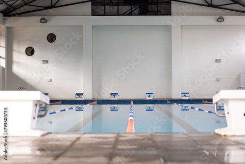 Swimmers are not visible, only an empty indoor pool awaits indoors, copy space