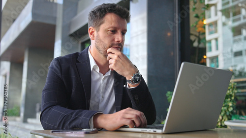 Handsome 30s top manager work laptop. Entrepreneur type computer macbook. Business man look monitor. Young male businessman. Urban city background. 40s employee create start up. Ceo office boss job.