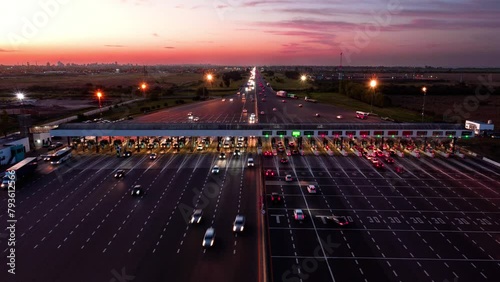 Cars pass through Hudson toll booth by Buenos Aires, static timelapse at dusk