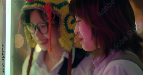 Two friends look intently and then sadden at night time carnival fair
