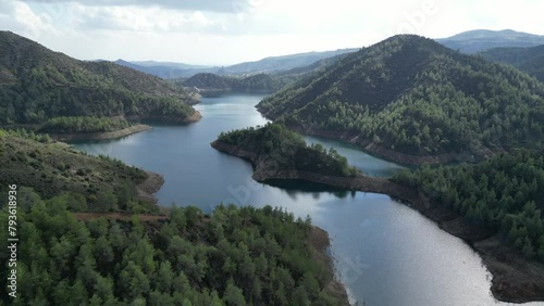 Drone flyover Lefkara dam reservoir with green hills on a calm day in Cyprus photo