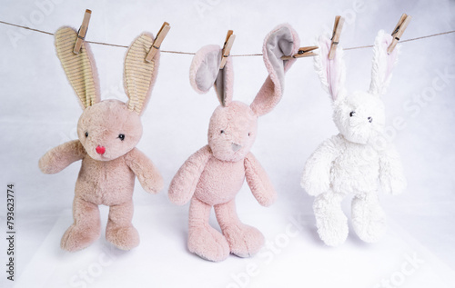 Toy hares hanging on a rope on clothespins
