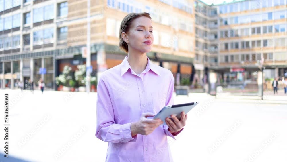 Young businesswoman standing on the street and using tablet Young businesswoman standing on the street and using tablet