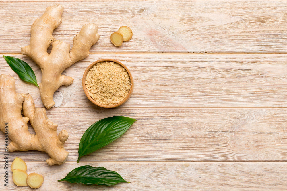 Finely dry Ginger powder in bowl with green leaves isolated on colored background. top view flat lay Finely dry Ginger powder in bowl with green leaves isolated on colored background. top view flat lay