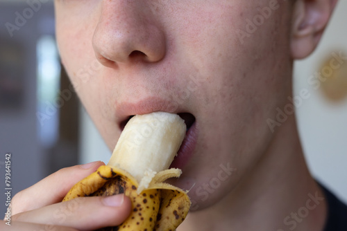 Detail of a Boy's Mouth Biting a Banana