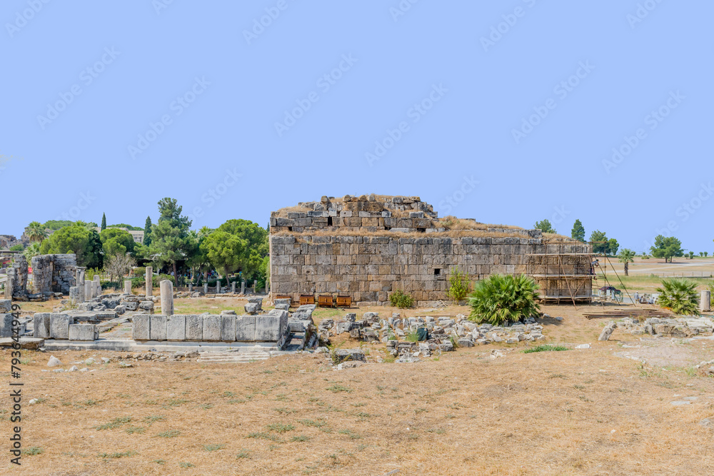 Sunny view of ancient ruins with large stone blocks forming part of a historical landmark at ancient site of Hierapolis in Pamukkale, Turkiye